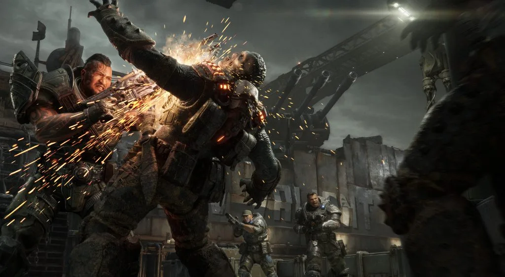 A COG soldier uses a chainsaw against an enemy drone during multiplayer combat.